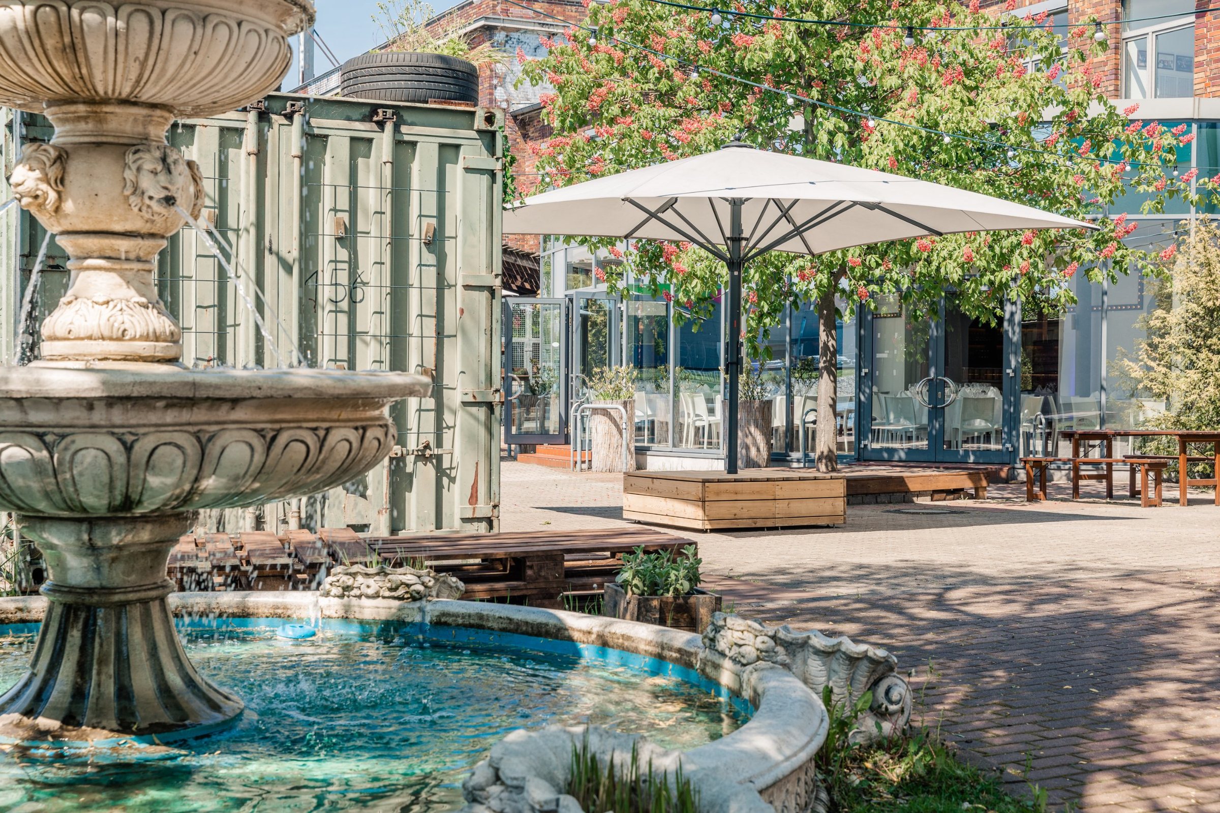 Innenhof mit Brunnen, Sonnenschirm und Glasfront des Lighthouse