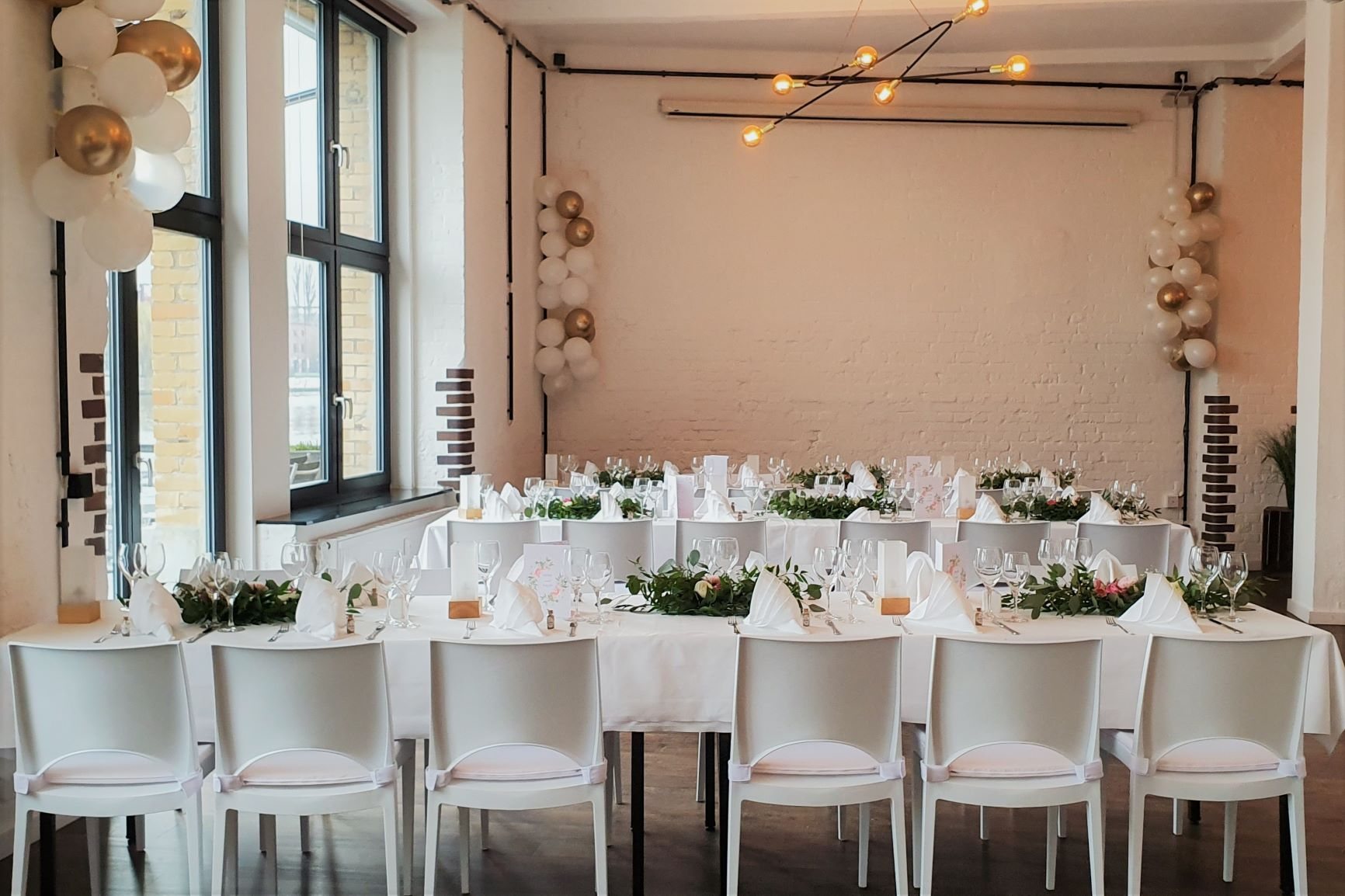 ALVA Lounge mit festlich gedeckter Tafel, Blumen und weiß-goldenen Ballons