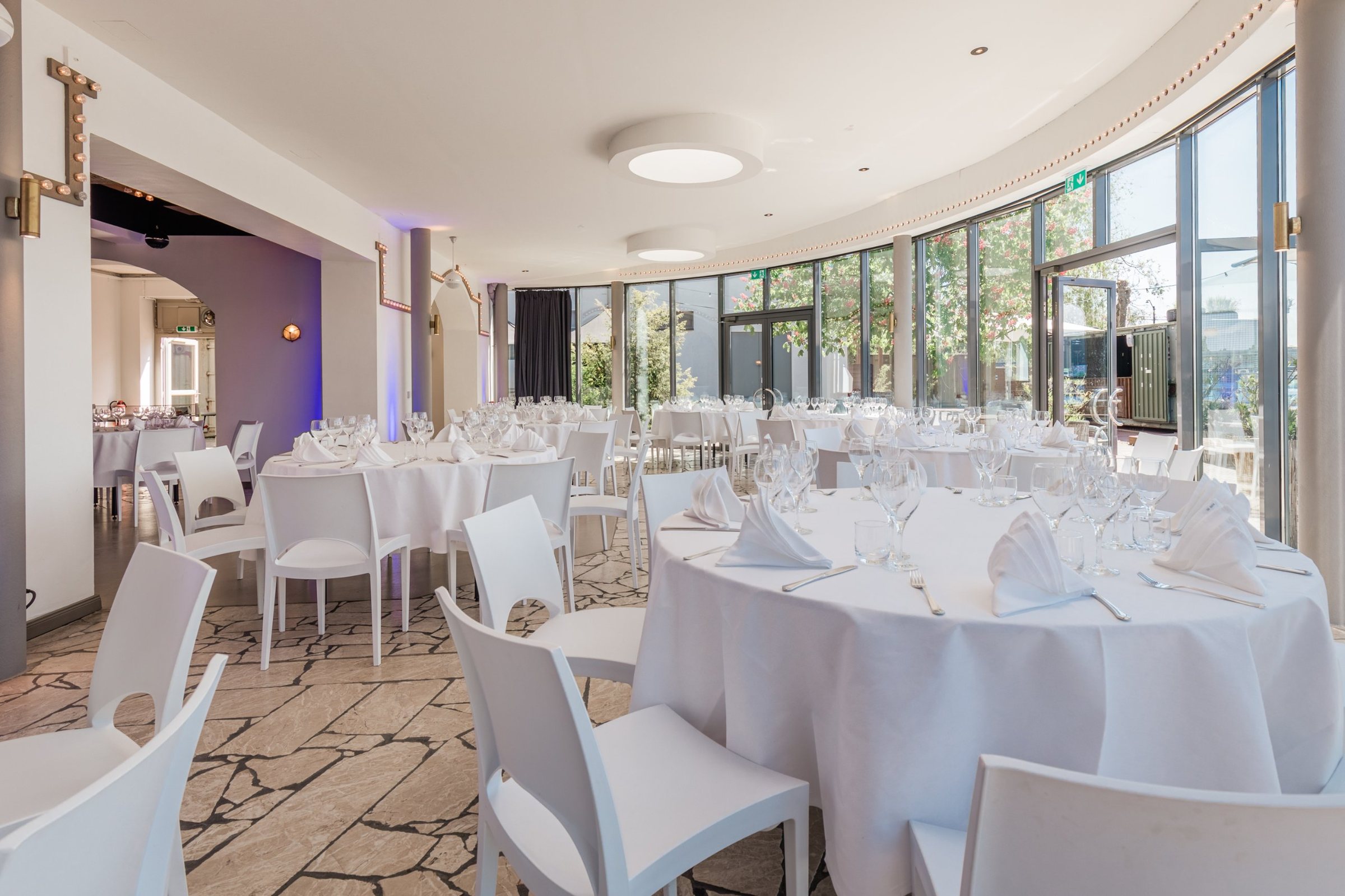 Panoramalounge der WHITE Spreelounge mit festlich gedeckten runden Tischen und Glasfront